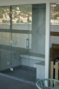 a glass shower stall with a tennis racket in it at Il Porticciolo in Laveno-Mombello
