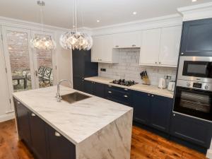 a kitchen with blue cabinets and a white counter top at Castlegate House in Lincoln