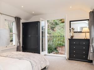 a bedroom with a black dresser and a large window at Castlegate House in Lincoln
