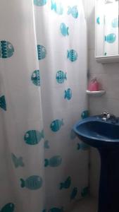 a bathroom with a shower curtain with fish on it at Depto La Cuni in Goya