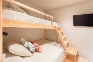 a bunk room with two bunk beds and a flat screen tv at Hotel Maritim in Roses