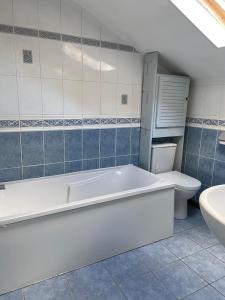 een badkamer met een bad, een toilet en een wastafel bij Maison au calme a l'orée du bois. Accès A13-A14 in Orgeval