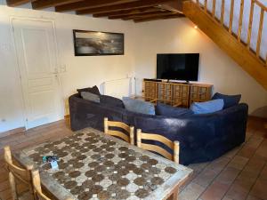 een woonkamer met een bank en een tafel bij Maison au calme a l'orée du bois. Accès A13-A14 in Orgeval