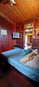 a bedroom with a bed with a tv on the wall at CASA DE CAMPO PATRIMÔNIO in Brotas