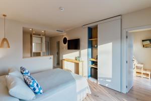 a bedroom with a large white bed and a tv at Hotel Maritim in Roses