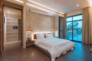 a bedroom with a large bed and a large window at The Valley Resort in Riyadh