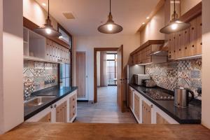 a large kitchen with wooden cabinets and black counter tops at The Valley Resort in Riyadh