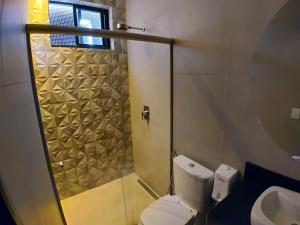 a bathroom with a shower and a toilet and a sink at Motel Caribe in Belo Horizonte