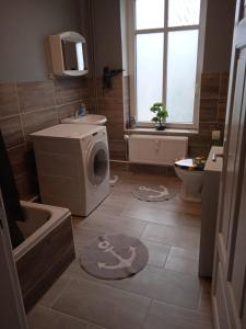 a bathroom with a washing machine and a sink at Flensburg Zentrum 50 01 in Flensburg +4 photos