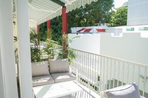un balcón con un banco y plantas. en Casa Wilson Inn, en San Juan