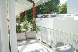 a balcony with a bench and plants on it at Casa Wilson Inn in San Juan