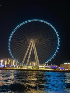 a large ferris wheel is lit up at night at LiveIn Holiday Homes - JBR in Dubai