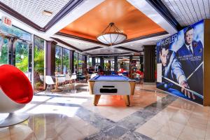 a room with a pool table and a large screen at Chateau Mar Golf Resort, Trademark Collection by Wyndham in Lauderhill