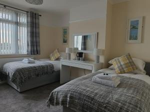 a bedroom with two beds and a desk and a mirror at The Ship Inn Folkestone in Folkestone