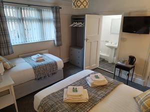 a hotel room with two beds and a bathroom at The Ship Inn Folkestone in Folkestone