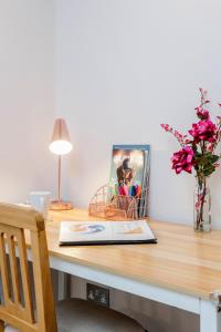 a desk with a laptop and a vase of flowers at MPL Apartments - Watford The Junction Short-Term Rentals - 2bed-FREE PARKING in Watford