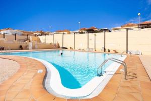 a swimming pool with a slide in front of a building at Manuda Luxury Apartment in Caleta De Fuste