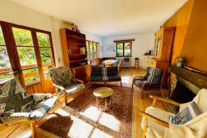 un salon avec plusieurs chaises et une cheminée dans l'établissement Family Cottage With Garden In Saint Chaffrey, à Saint-Chaffrey