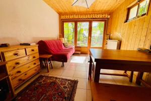 un salon avec une chaise rouge et un bureau dans l'établissement Family Cottage With Garden In Saint Chaffrey, à Saint-Chaffrey