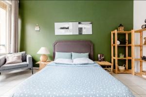 a bedroom with a bed and a green wall at Apt Chic, 60m2, 2 Chambres, Centre in Valenciennes