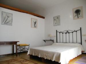 Un dormitorio con una cama y un piano. en Can Selleretas, en Vilamacolum