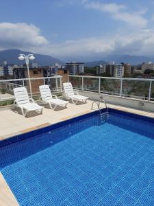 una piscina en la azotea de un edificio en Apartamento completo p temporada Ubatuba, excelente localização com conforto e economia, en Ubatuba