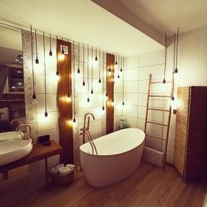 a bathroom with a tub and two sinks and lights at GÓRNA VIBES in Jugowice