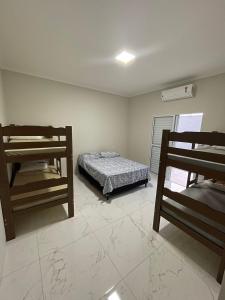 a bedroom with a bed and two bunk beds at Casa De Temporada Eldorado in Olímpia