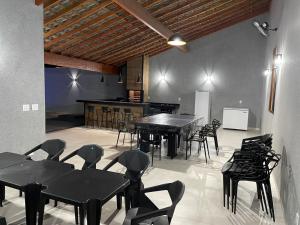 a dining room with black tables and chairs at Casa De Temporada Eldorado in Olímpia