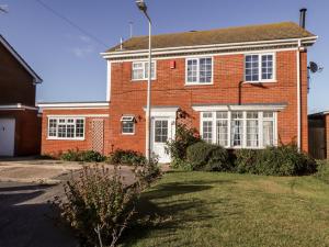 uma casa de tijolos vermelhos com uma porta branca em 17 St Magnus Close em Birchington