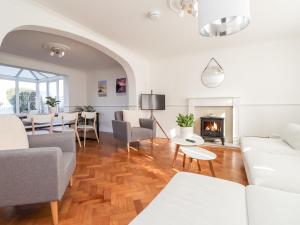 a living room with white furniture and a fireplace at 17 St Magnus Close in Birchington