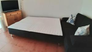 a bed in a room with a couch and a tv at Wohnung Bernstein - Nr. 4 in Dierhagen