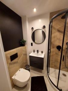 a bathroom with a toilet and a sink and a mirror at Apartament Rodzinny in Kłodzko