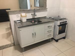 una cocina con fregadero y estufa en Apartamento Caiçaras 1, en Belo Horizonte