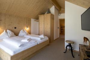 a bedroom with a bed and a flat screen tv at Wellness Chalet Bell a Mur in Murau
