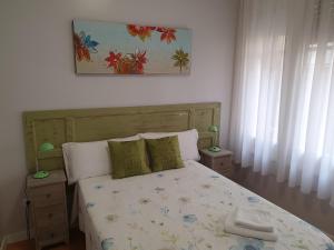 1 dormitorio con 1 cama con 2 mesas y 1 foto en Pensión Sotelo en Logroño