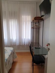 1 dormitorio con escritorio, 1 cama y ventana en Pensión Sotelo, en Logroño