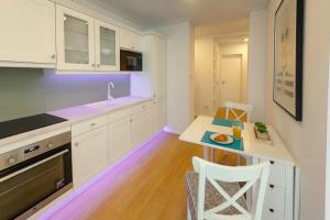 a kitchen with white cabinets and a small table at Hip riverview bestern in Szeged