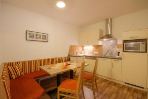 a kitchen with a wooden table and a dining room at Apart Mado in Längenfeld