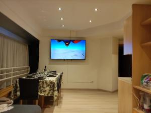 a dining room with a table and a projection screen at Doss della Pesa Apartment - CIPAT 22114 in Marilleva