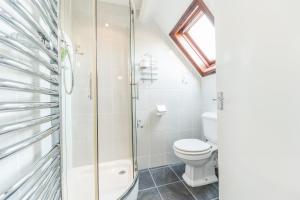 a bathroom with a toilet and a glass shower at Rayrigg Villa Windermere (Room Only) in Windermere