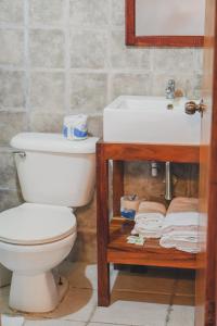 a bathroom with a white toilet and a sink at Hotel Buenos Aires in Santa Teresa Beach