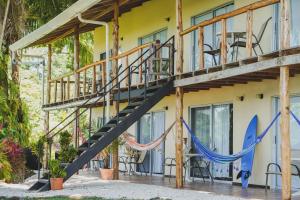 a house with a staircase and a surfboard at Hotel Buenos Aires in Santa Teresa Beach
