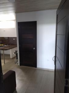 a black door in a room with a table at Aparta-Hotel LENEMBERGER in Puerto Asís