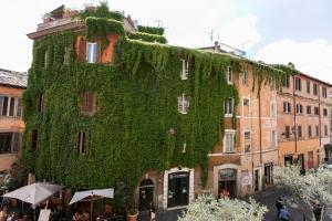 a building with green ivy on the side of it at Sonder Trastevere in Rome