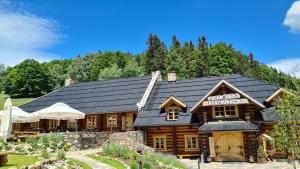 a log cabin with a black roof at Aparthotel Apartamenty Czarna Góra 340 in Sienna
