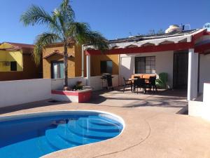 a swimming pool in front of a house with a table at Casa Llena de Vida LB8 Alberca privada VISTA A LA BAHIA in San Carlos
