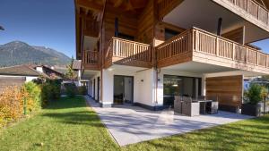a house with a deck and a lawn at Chalet Alpenspirit in Garmisch-Partenkirchen