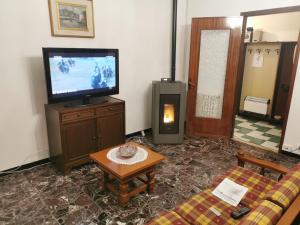a living room with a couch and a television at Villa Olga - Lunigiana in Filattiera