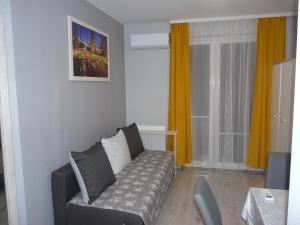 een woonkamer met een bank en een raam bij Apartament w centrum Ciechocinka in Ciechocinek